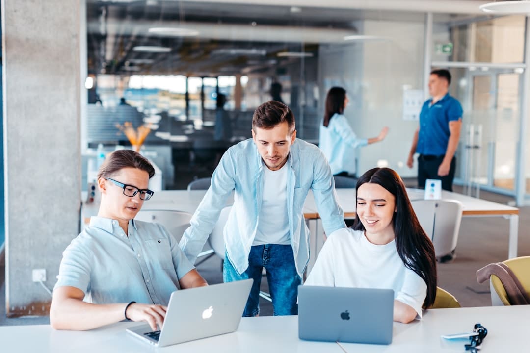 IT consulting team discussing a growth strategy around a laptop