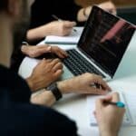 How to Choose an AI Automation Provider in Malta: Due-Diligence Checklist 1 Business team reviewing an AI automation provider proposal around a laptop