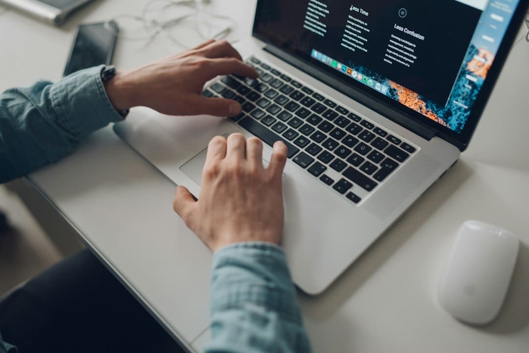 Business professional editing website content on a laptop