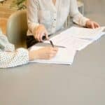 Business representatives reviewing and signing a website development contract